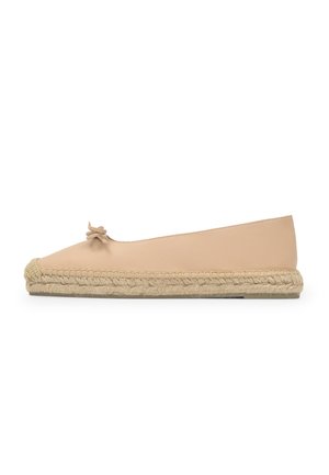 Zapato plano beige de tipo slip-on con suela de yute tejido y un pequeño lazo decorativo en la parte superior, mostrado de perfil sobre un fondo blanco.