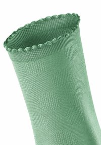 Chaussette vert clair avec un motif texturé, une bordure festonnée et une finition lisse. Le tissu semble extensible et respirant.