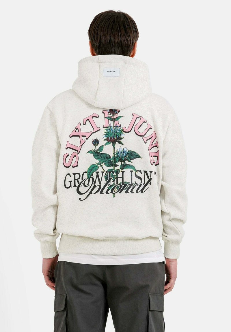 Lichtgrijze hoodie met een bloemig grafisch ontwerp op de achterkant, met de teksten "SIXTH JUNE" en "GROEI IS GEEN OPTIE." Gemaakt van een katoenmix.