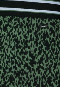 Grön mönstrad tyg med ett svart leopardliknande tryck. Tillsammans med ett midjeband i svart, vitt och grönt med en metalltag.