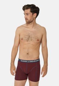 Boxer in borgogna con elastico blu navy, con logo. Tessuto morbido con una consistenza liscia, progettati per comfort e supporto.