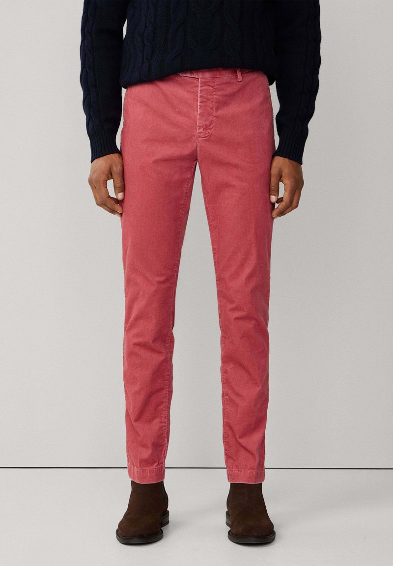 Rode katoenen chino broek met een slim fit en subtiele textuur, met zijzakken en een taps toelopend model, gedragen met donkerbruine enkelboots.