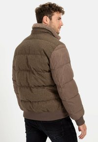 Brun pufferjakke med struktureret stof, fleece Krave og kontrasterende glat ærmemateriale. Ribbet søm og detaljeret syning.