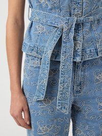 Τζιν γιλέκο και παντελόνι με ανοιχτό γκρι κεντήματα με λουλούδια, διαθέτουν ζώνη δεμένη στη μέση και εμφανές αριστερό χέρι και χέρι.