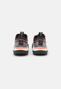 Scarpe sportive nere e grigie con dettagli arancioni, tomaia in rete, suola testurizzata e colletto imbottito. Presentano il logo sul tallone e il marchio.