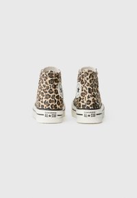 Wysokie trampki z płótna w leoparda z czarnymi akcentami, z białymi gumowymi podeszwami i logo Converse na pięcie.