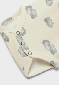 Salopetă de culoare crem, fabricată din bumbac moale, cu modele de nori gri deschis și închideri prin capse la gât și la picioare.
