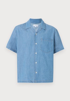 Lichtblauw denim overhemd met korte mouwen, knopen aan de voorkant, een puntige kraag en een borstzak op een effen achtergrond.