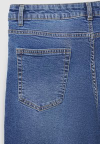 Jeans di denim blu con una tasca posteriore standard, caratterizzati da cuciture arancioni a contrasto e una superficie del tessuto strutturata.