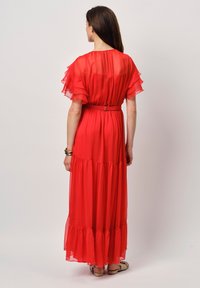 Maxi-jurk in felrood, gemaakt van lichtgewicht, semi-doorzichtig materiaal. Kenmerken zijn de vlindermouwen, geschulpte lagen en een cinched taille met een riem.