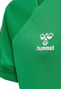 Groen sportshirt van ademend materiaal met een gestructureerd patroon. Het logo "hummel" in het wit prominent weergegeven op de borst.