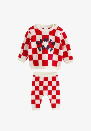 Sarkans un balts rūtainas bērnu džemperis ar uzrakstu "SANTA BABY" jūras zilā krāsā, kombinēts ar atbilstošām rūtainām biksēm, viss mīksta adījuma audumā.