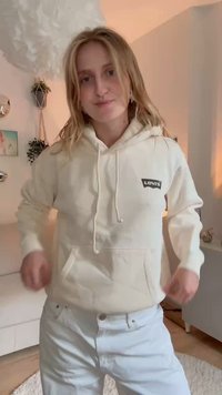 Krémová mikina s kapucňou vyrobená z mäkkej tkaniny, vybavená predným vreckom, šnúrkami a čiernou nášivkou s logom Levi's na ľavej hrudi.