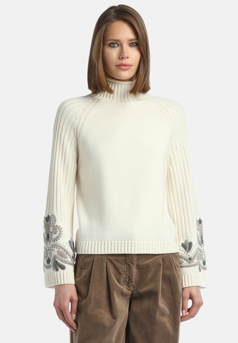 Maglione bianco a coste con colletto alto e complessa ricamata floreale grigia sui polsini, caratterizzato da una silhouette aderente e un tessuto testurizzato.