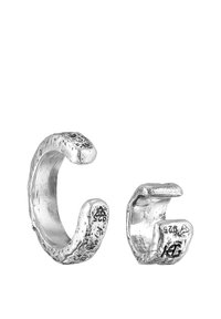 Silverfärgade ringar med dubbla band och en texturerad yta. En är större och böjd, den andra mindre med ingraverade detaljer. Båda har en öppen design.