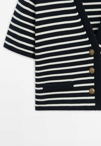 Cardigan à manches courtes rayé horizontalement bleu marine et blanc, avec bordure texturée bleu marine, trois boutons dorés et une petite poche sur le côté gauche.