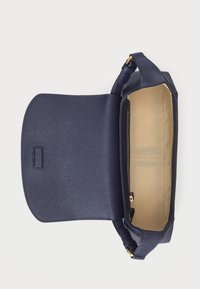 Navy blue faux leather handbag with a textured surface, featuring a magnetic flap closure and a beige-lined interior with a zipper pocket.