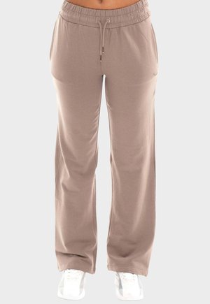 Pantaloni della tuta a gamba larga color taupe con vita elasticizzata e coulisse, indossati con sneakers bianche su sfondo neutro.