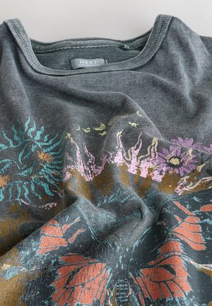 Dunkelgraues Baumwoll-T-Shirt mit entspannter Ausschnittform, das einen mehrfarbigen Blumen- und Schmetterlingsdruck in den Farbtönen Rosa, Blau und Orange zeigt.