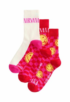 Drei Paar Socken: ein weißes Paar mit pinkem "NIRVANA"-Schriftzug und zwei rote mit gelben smiley Gesichtern und einem pinken Schachbrettmuster.