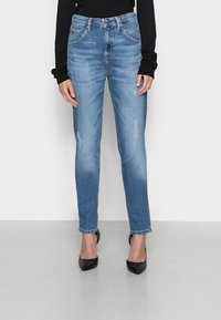 Ljusblå smala jeans i denim med medelhög midja, klassisk femficksdesign och lite slitningar framtill.