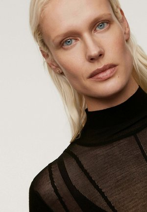 Top negro, transparente, de manga larga y cuello alto. Presenta un patrón de rayas horizontales y detalles acanalados a lo largo de los bordes.
