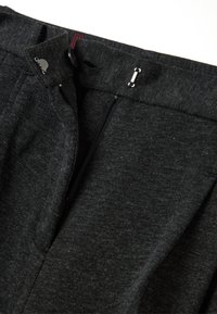 Pantaloni in tessuto grigio scuro con una texture liscia, dotati di una cerniera e un gancio metallico, oltre a delicate pieghe in vita.
