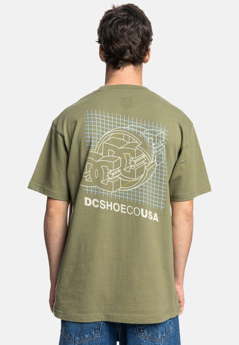 Olive green cotton t-shirt featuring a graphic design with circular shapes and grid pattern on the back. Short sleeves, relaxed fit.