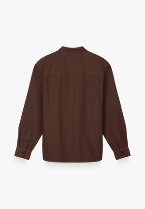Hnedá košeľa s dlhým rukávom a zapínateľnými manžetami zobrazená zozadu, so strihom na rovný lem a švom naprieč hornou časťou chrbta.
