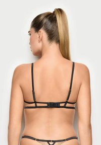 Sort lingeri med justerbare stropper, som har blonder detaljer bagpå. Designet inkluderer en hægtslukning og en glat overflade.