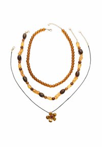 Collane a tre strati con perline ambra e marroni, sostenute da un filo nero che tiene un pendente a forma di fiore con un centro rosso.