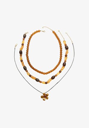 Trzy warstwowe naszyjniki z bursztynowymi i brązowymi koralikami, na czarnym sznurku z zawieszką w kształcie kwiatu z czerwonym środkiem.