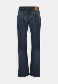 Vaqueros Levi's de pierna recta en azul oscuro mostrados desde atrás, con costuras visibles, dos bolsillos traseros y un parche de cuero color marrón en la cinturilla.