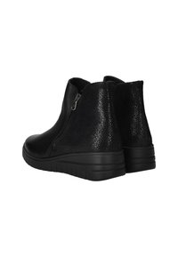 Bottes noires à la cheville en cuir lisse et texturé, avec une fermeture éclair sur le côté et une semelle en caoutchouc robuste, dotées d'un léger talon surélevé.
