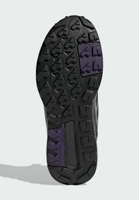 Shoe outsole featuring a textured black rubber surface with multi-directional lugs, purple accents, and a stabilizing support section.