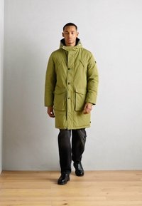 Zelený zateplený parkas s kapucňou, so prednými vreckami a gombíkovým zapínaním. Vyrobený z hladkého, odolného materiálu; teplý a funkčný dizajn.