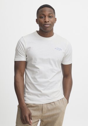 Weißes T-Shirt mit kurzen Ärmeln aus Baumwolle, mit blauer bestickter Aufschrift "ALL YOU NEED IS LESS" auf der linken Brustseite.