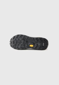 Black rubber outsole with deep tread patterns for traction, featuring a yellow Vibram logo. Textured surface and durable construction.