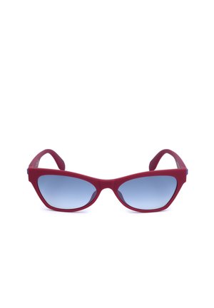 Occhiali da sole rossi stile occhio di gatto con lenti sfumate blu mostrati su uno sfondo bianco.