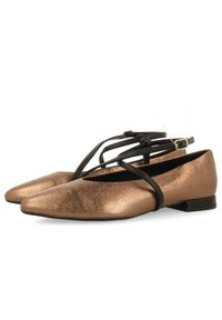 Bailarinas de punta en bronce metálico con acabado texturizado. Presentan correas negras entrelazadas y un bajo tacón negro para mayor estabilidad.