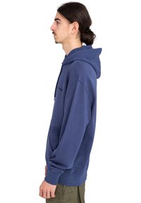 Sudadera de algodón azul marino con bolsillo canguro, puños y dobladillo acanalados. Cuenta con capucha con cordón y logo bordado en la parte frontal.