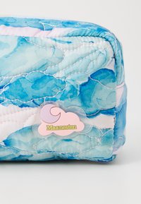 Quilted pouch with a blue watercolor pattern, featuring pink and blue tones. A cloud-shaped tag displays "Maanesten" in green text.