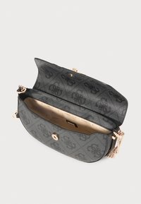 Black patterned handbag with a smooth exterior, gold-tone hardware, chain strap, and cream interior featuring the brand name.