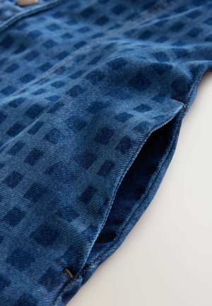 Tessuto di denim con una tonalità di blu scuro, caratterizzato da un sottile motivo a quadri. Il pezzo ha una consistenza morbida e cuciture visibili lungo i bordi.