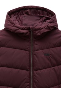 Burgundy uppblåst jacka med dragkedja fram, huva och ton-i-ton sömmar. Har ett sydda diamantmönster och en liten svart logotyp på bröstet.