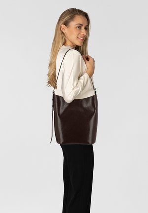 Bruine leren schoudertas met een glanzende afwerking, gladde textuur en verstelbare band. Eenvoudige vorm, geen zichtbare patronen of hardwaredetails.