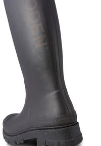 Botte de pluie noire en caoutchouc avec une semelle texturée, une tige lisse, un détail de logo et une légère brillance. Présente un design hauteur genou pour un bon coverage.