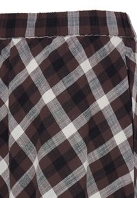 Tissu à carreaux marron et noir avec des lignes blanches et une taille élastique, probablement une partie d'un vêtement comme un pantalon ou un short.