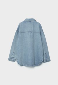 Lichtblauwe denim jas met lange mouwen, knoopsluitingen bij de manchetten, rechte achternaad en afgeronde zoom op een effen witte achtergrond.