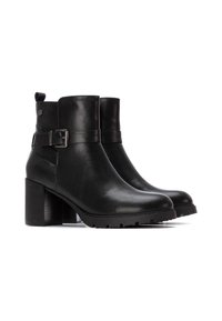 Botas de tobillo de cuero negro con tacón ancho, que cuentan con un detalle de hebilla lateral y una suela texturizada para ofrecer agarre. Acabado suave y diseño moderno.